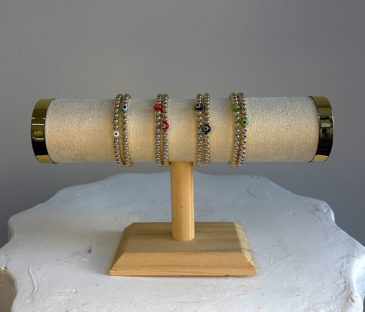 Gold-filled beaded bracelets with a glass evil eye in white, turquoise, red, black, and green